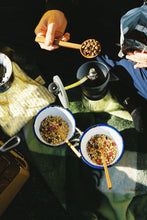 Load image into Gallery viewer, A hand carved coffee scoop scooping coffee beans into a grinder.