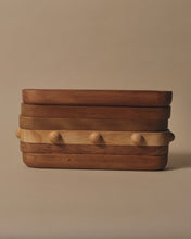 Load image into Gallery viewer, A stack of Long Trays in Rimu, Swamp Kauri and Matai, one tray has 8 half spheres around the edge in equal distance from each other
