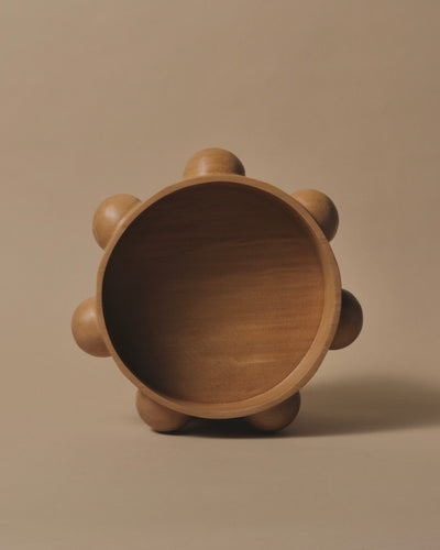 Large round Kauri bowl with a flat base and 7 hand carved half spheres in equal distance from each other around the outside edge.