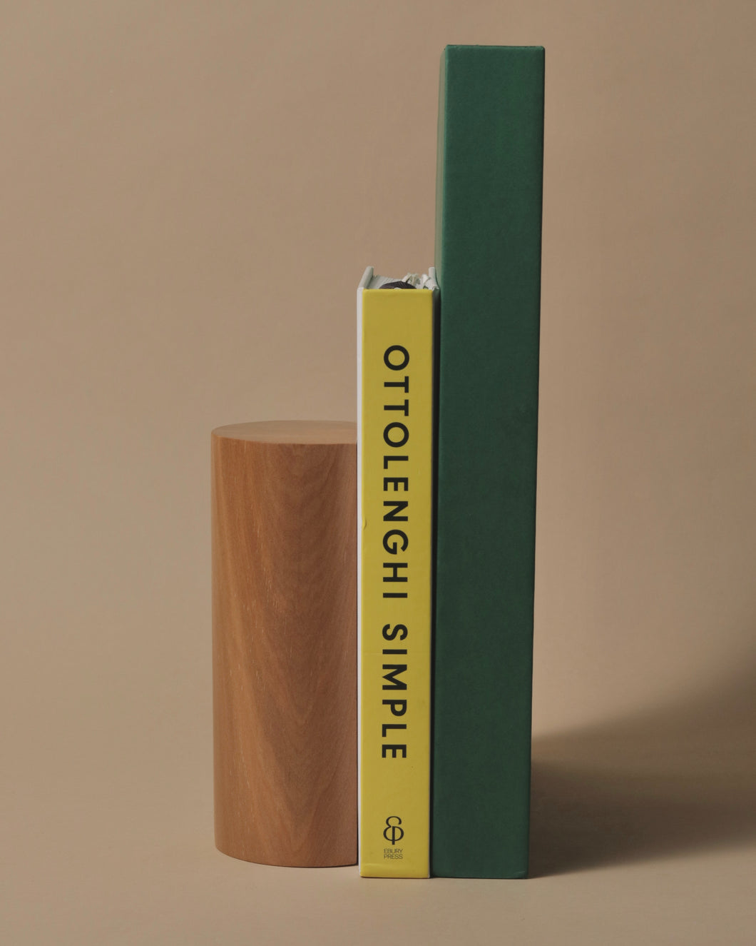 Handcrafted oak bookend holding two books, including 'Ottolenghi Simple,' showcasing a minimalist and elegant design.