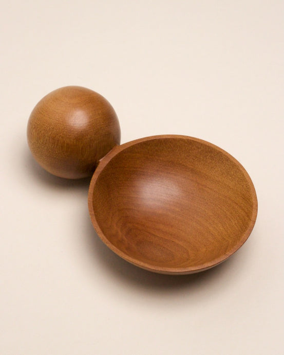 A hand carved spoon made of swamp kauri on a white back ground, the spoon bowl is deep and round and the handle is a hand carved sphere.