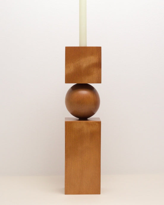 Hand-carved kauri candleholder from the Moon Series, featuring a spherical base atop a square block.